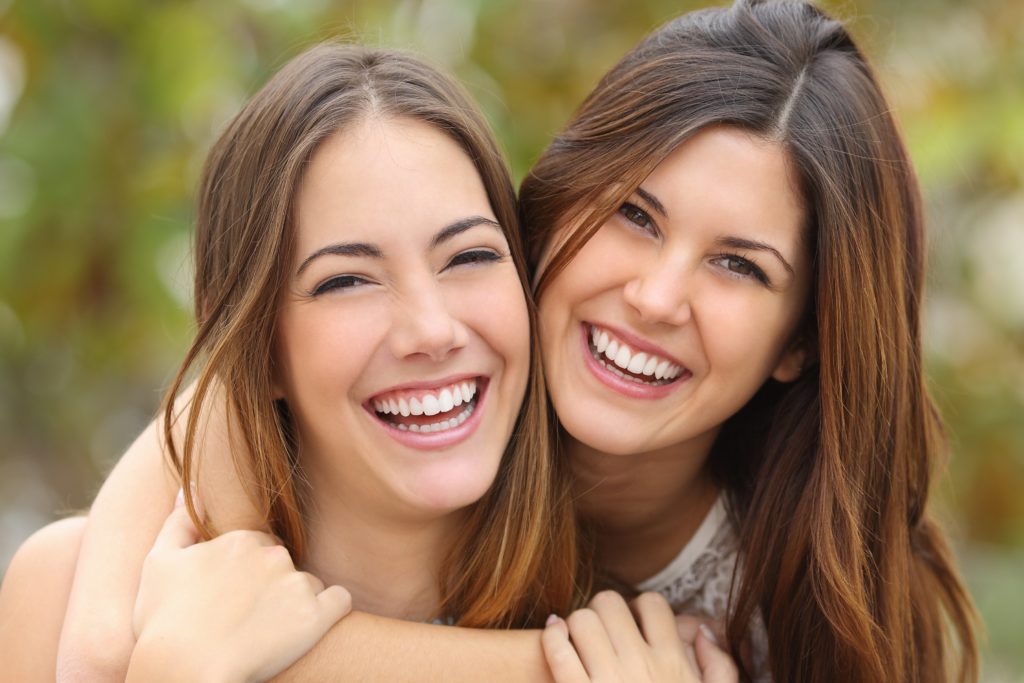 Two young girls hug and smile for the camera