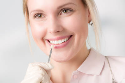 woman choosing which shade of dental veneer she would like