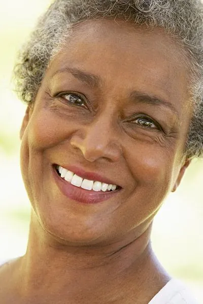 woman showing off a freshly restored smile after getting dental implants at Comprehensive Dentistry in Ypsilanti, MI