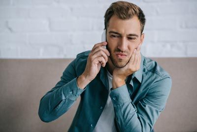 man calling the dentist for an emergency appointment